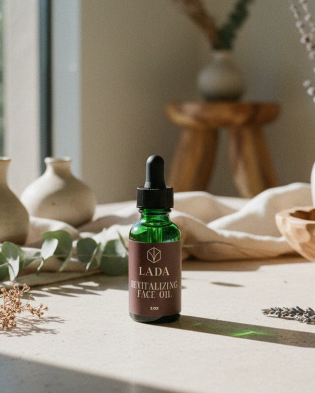 LADA Revitalizing Face Oil bottle on a table with decorative items in the background, natural skincare from LADA Beauty serving El Paso, TX