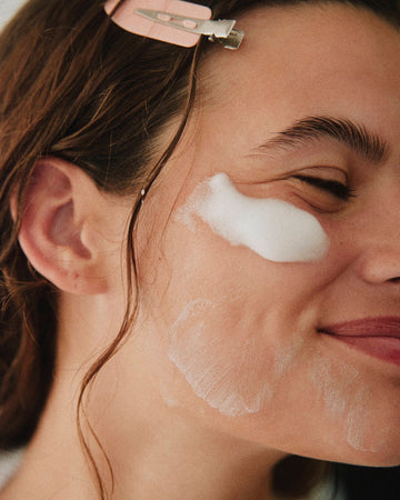 social media content creator image with foaming cleanser on cheeks